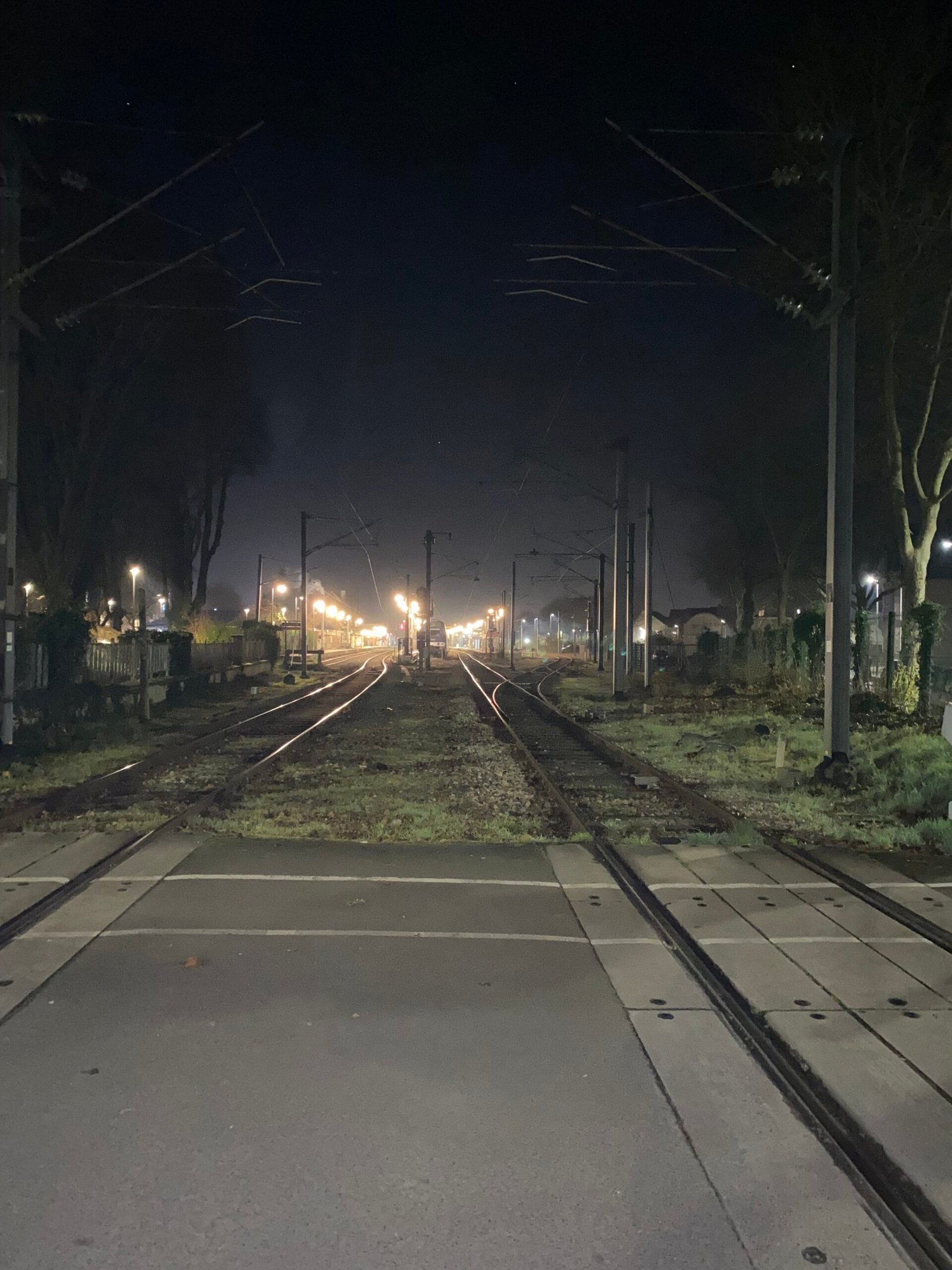 Rails de train la nuit, lumières lointaines dans le brouillard — illustration de l'isolement et de la solitude dans le film The Whale