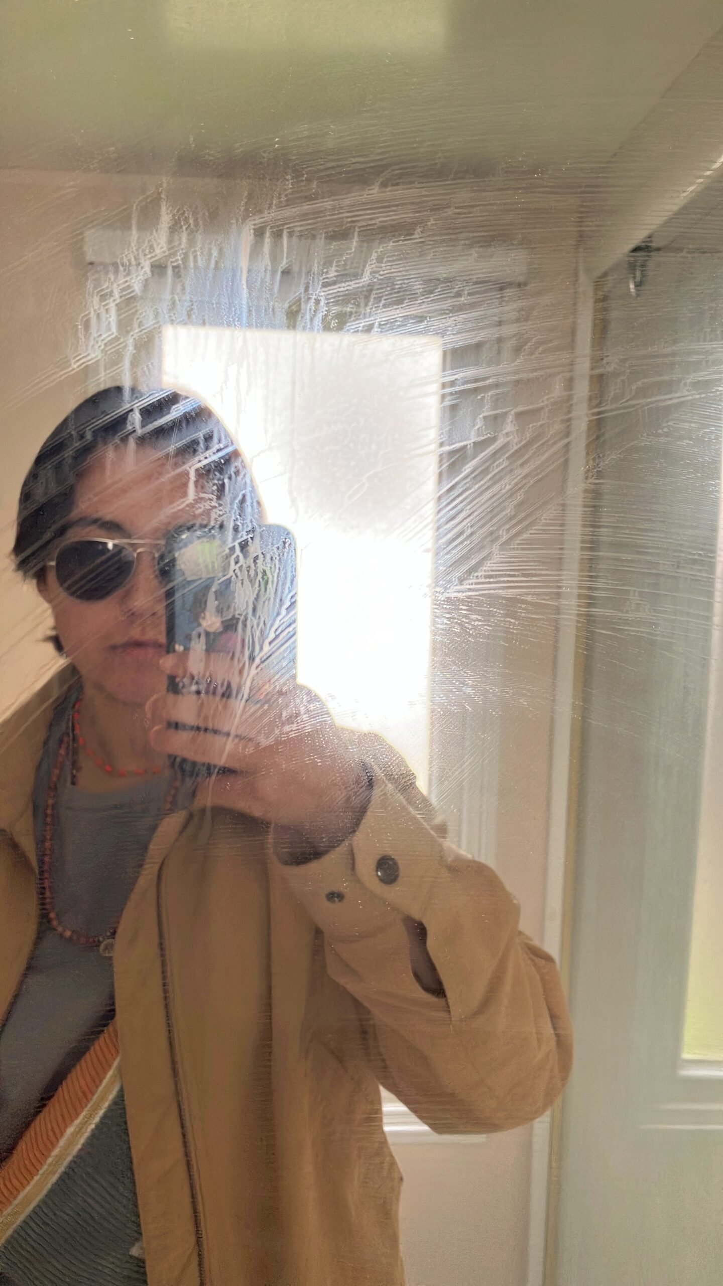 Selfie dans un miroir rayé, veste camel, lunettes aviateur — Villevaude avril 2025