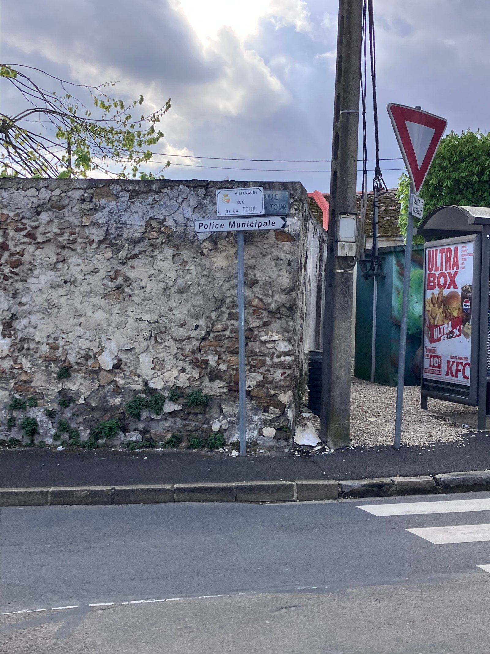 Panneau Police Municipale sur vieux mur de pierre, pub KFC en arrière-plan — Villevaude avril 2025